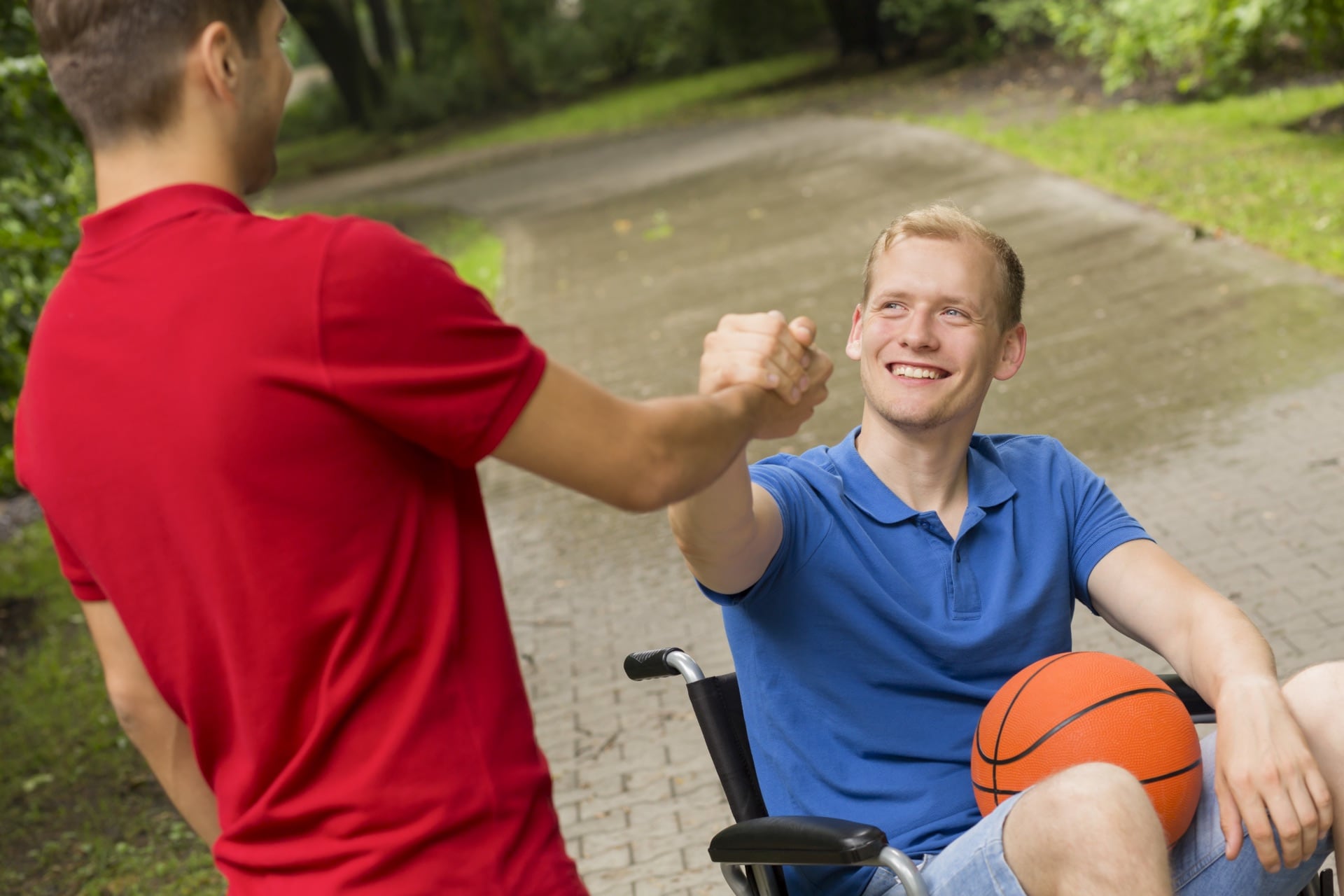 Jeune homme en fauteuil roulant avec un ballon de basket